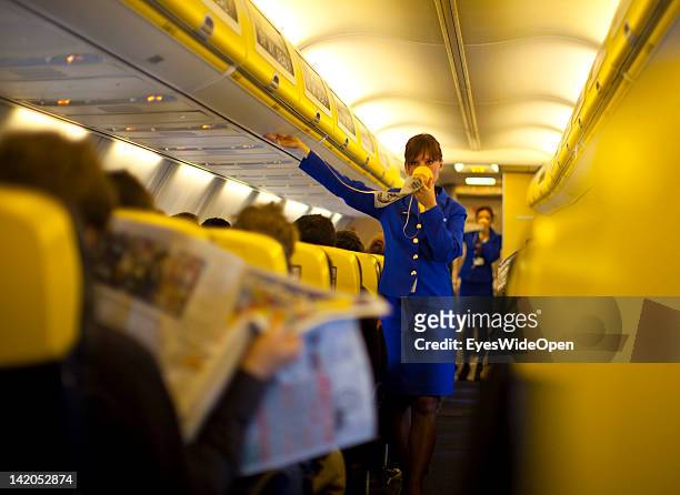 Safety instructions shown by a stewardess for Passengers boarding for departure of a RyanAir flight to Alicante, Spain at Allgaeu Airport on February...