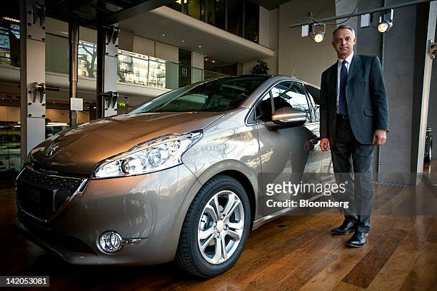 Xavier Peugeot, product director for the Peugeot SA brand, poses for a photograph alongside the new Peugeot 208 automobile, produced by PSA Peugeot...