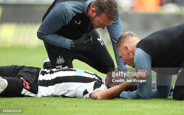 Joe Willock of Newcastle United receives medical treatment after colliding with Vicente Guaita of Crystal Palace , leading to a VAR decision to rule...