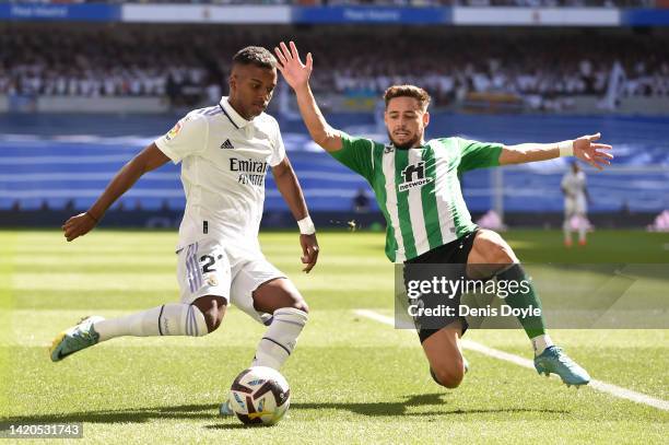 Rodrygo of Real Madrid is tackled by Alex Moreno of Real Betis during the LaLiga Santander match between Real Madrid CF and Real Betis at Estadio...