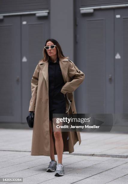 Elise Seitz seen wearing white Celine sunglasses, black oversize shirt from Soho Studios, matching black Soho Studios shorts, beige oversize Soho...