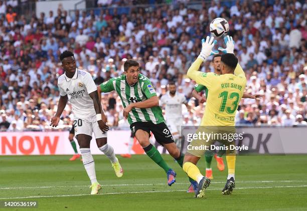 Vinicius Junior of Real Madrid shoots the ball past Rui Silva of Real Betis to score their team's opening goal during the LaLiga Santander match...