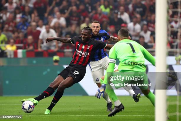 Rafael Leao of AC Milan scores their side's third goal whilst under pressure from Samir Handanovic of FC Internazionale during the Serie A match...