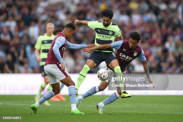 Ilkay Gundogan of Manchester City battles for possession with Jacob Ramsey and Boubacar Kamara of Aston Villa during the Premier League match between...