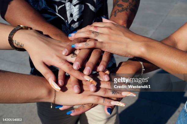 hand's of friends stacked together on sunny day - artificial nails stock pictures, royalty-free photos & images