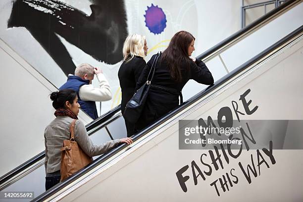 Customers use escalators to move to retail floors inside an Hennes & Mauritz AB store in Malmo, Sweden, on Thursday, March 29, 2012. Hennes & Mauritz...