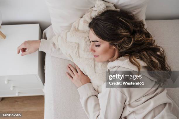 young woman resting on bed at home - man sleeping pillow stock-fotos und bilder