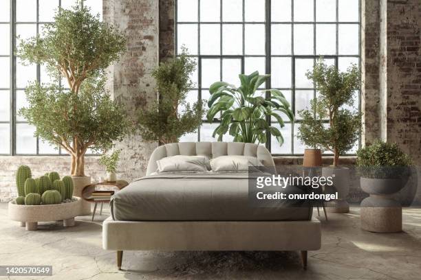 environmentally friendly bedroom with front view of  bed, green plants and brick wall - lifestyle backgrounds stock pictures, royalty-free photos & images