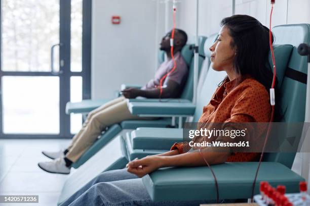 man and woman donating blood in hospital - donate stock-fotos und bilder