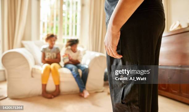 cropped shot of mother standing in living room with kids sitting looking guilty on sofa - house rules stock pictures, royalty-free photos & images