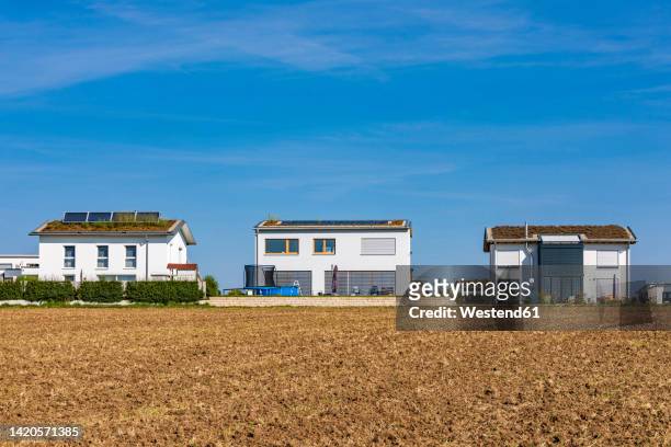 germany, baden-wurttemberg, sindelfingen, field in front of modern suburban houses - detached stock pictures, royalty-free photos & images