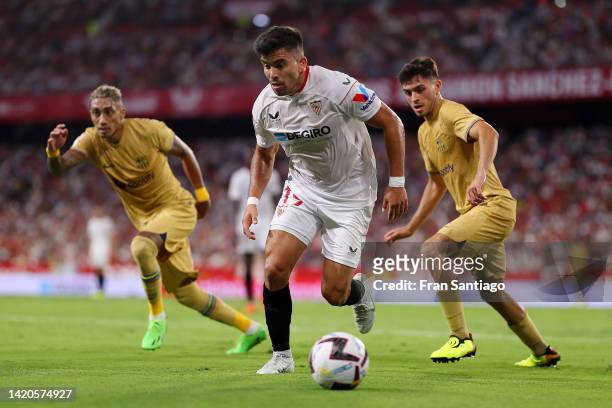 Marcos Acuna of Sevilla FC is marked by Raphinha and Pedri of FC Barcelona during the LaLiga Santander match between Sevilla FC and FC Barcelona at...