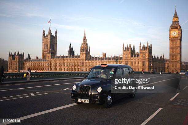 Black taxi cab makes its way over Westminster Bridge on March 28, 2012 in London, England.