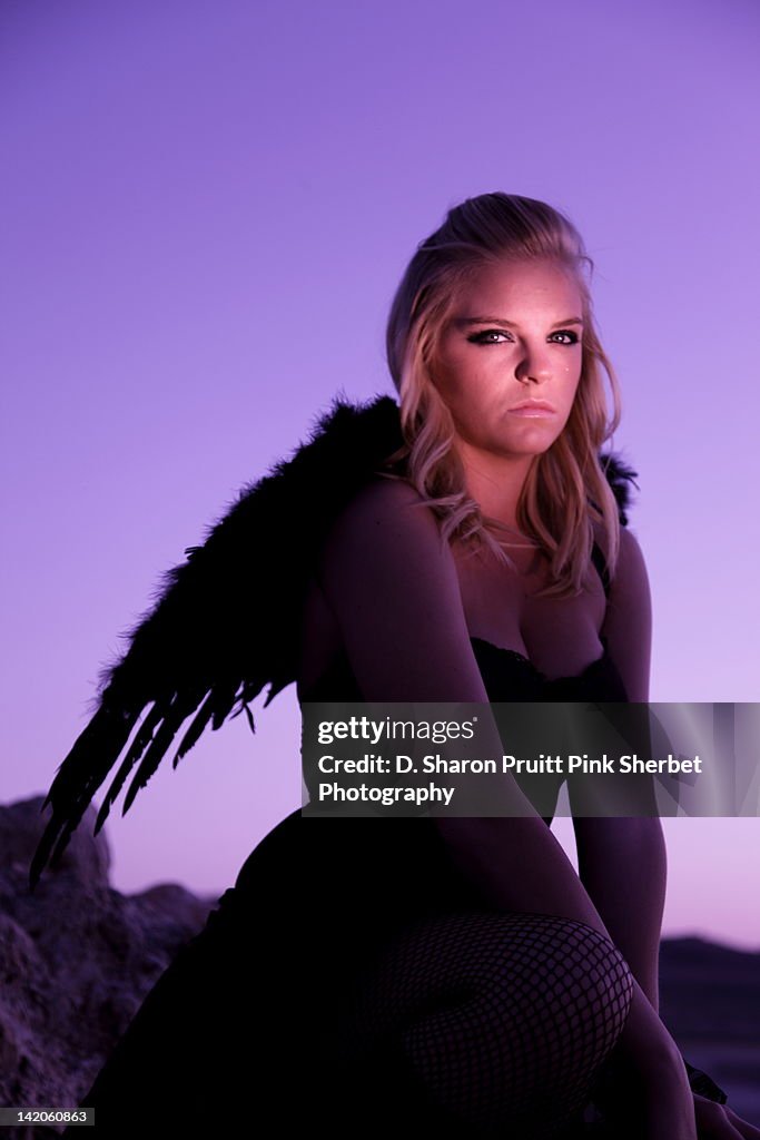 Dark angel girl against purple sky