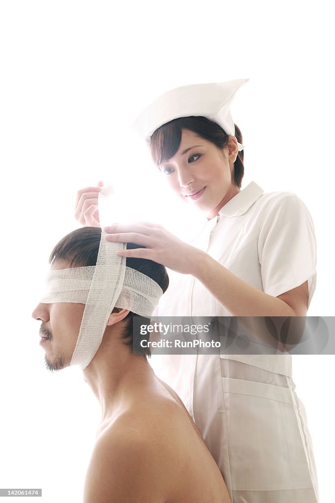 Young nurse dressing a mans head