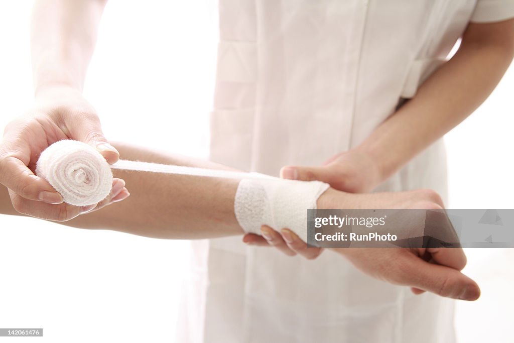 Young nurse dressing a mans hand,close-up