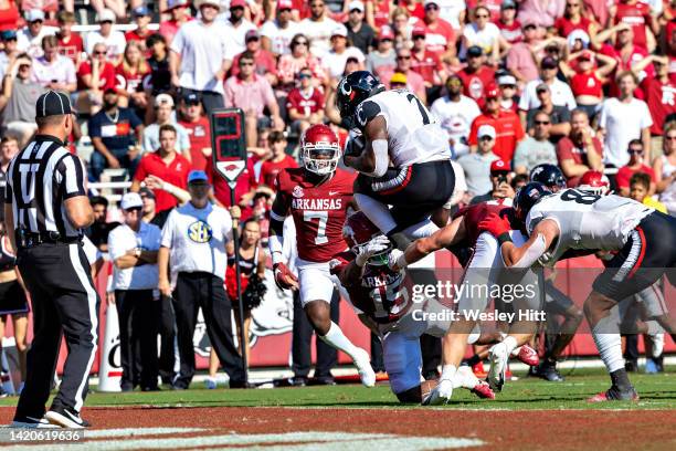 Corey Kiner of the Cincinnati Bearcats jumps over the tackle into the end zone for a touchdown in the third quarter of a game against the Arkansas...