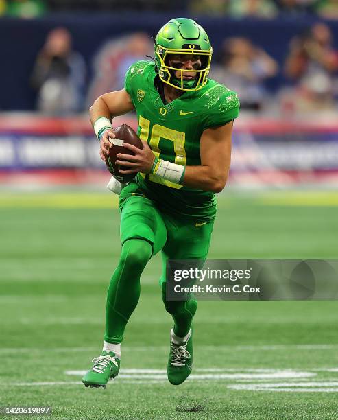 Bo Nix of the Oregon Ducks rushes out of the pocket against the Georgia Bulldogs during the first half of the Chick-fil-A Kick-Off Game between...