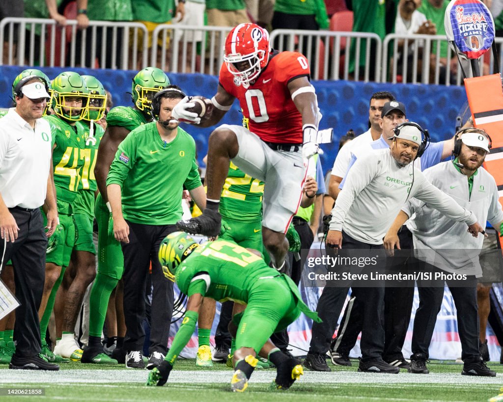 Darnell Washington of the Georgia Bulldogs leaps over Bryan Addison ...