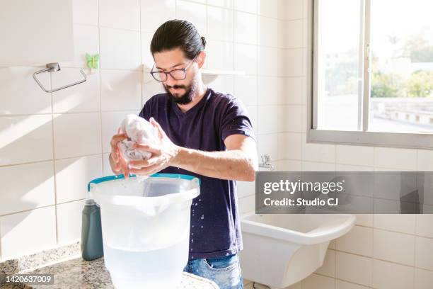 young latin man performing cleaning in empty apartment. - daily bucket bildbanksfoton och bilder