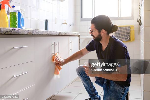 jovem latino fazendo limpeza em apartamento vazio. - limpo - fotografias e filmes do acervo