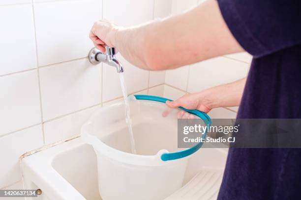 joven latino realizando limpieza en apartamento vacío. - daily bucket fotografías e imágenes de stock