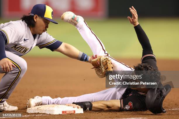 Alek Thomas of the Arizona Diamondbacks avoids a tag from infielder Keston Hiura of the Milwaukee Brewers during the sixth inning of the MLB game at...