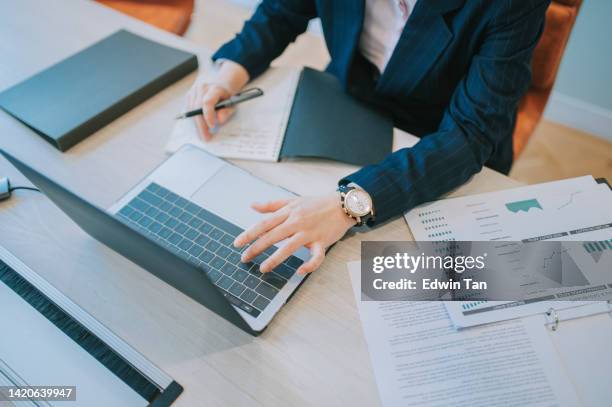 high angle asian chinese female manager focus working writing notes reading email from laptop in meeting room - ekonomisk rapport bildbanksfoton och bilder