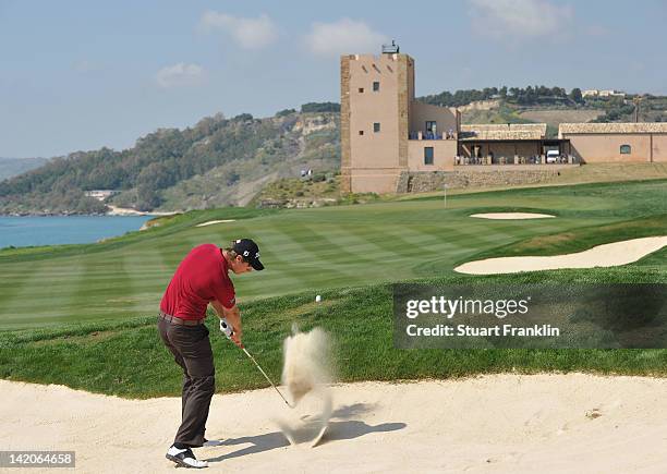 Nicolas Colsaerts of Belgium plays a bunker shot during the first round of the Sicilian Open at Verdura Golf and Spa Resort on March 29, 2012 in...