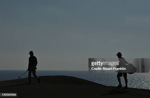 Tom Lewis of England and caddie Colin Byrne walk during the first round of the Sicilian Open at Verdura Golf and Spa Resort on March 29, 2012 in...