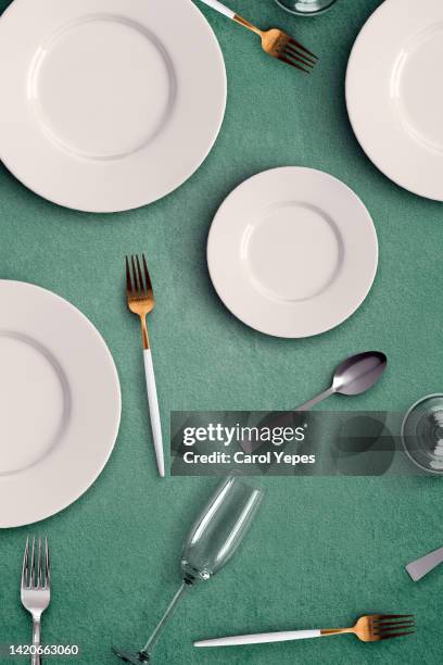 empty plate table setting i with forks, spoons, glasses in green background - carol cook stock pictures, royalty-free photos & images