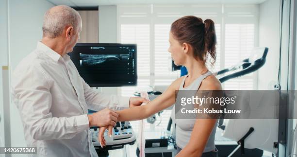 healthcare, medicine and fitness with a doctor and patient in a hospital to examine and x ray a broken arm injury. consulting, training and sports with an injured athlete in need of medical surgery - clinic stock pictures, royalty-free photos & images
