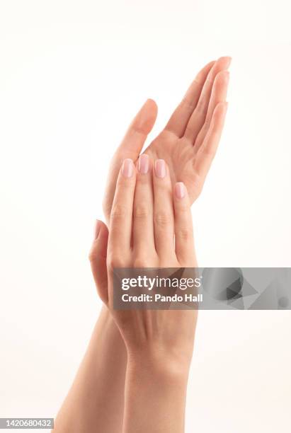 close up of two well manicured women hands - professional hand model - fingernägel lackieren stock-fotos und bilder