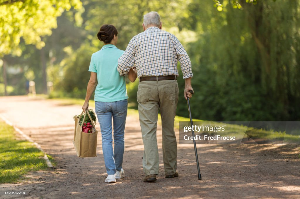 Caregiver – woman helping senior man with shopping
