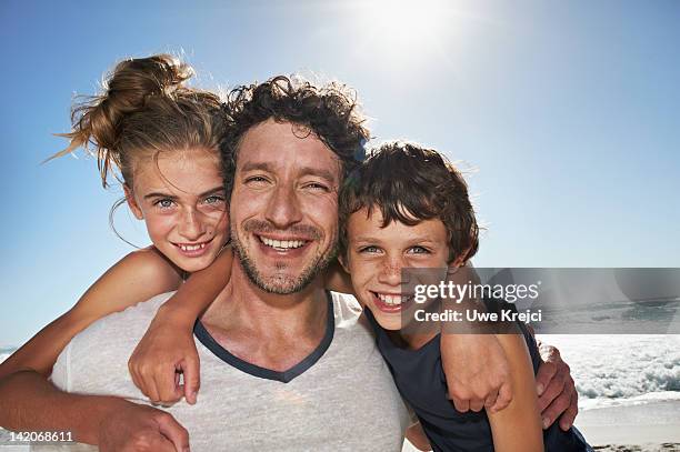 father playing with daughter and son - three girls at beach stock pictures, royalty-free photos & images