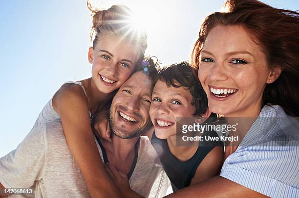 family on beach - four people smiling foto e immagini stock