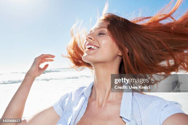 young woman shaking head, outdoors - scuotere i capelli foto e immagini stock