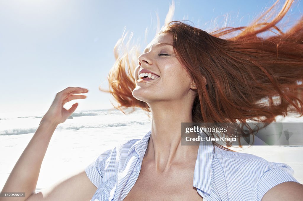 Young woman shaking head, outdoors