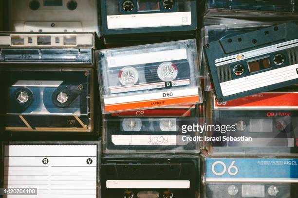 close-up image of some old obsolete cassette tapes of different colors from above - retro music stock-fotos und bilder
