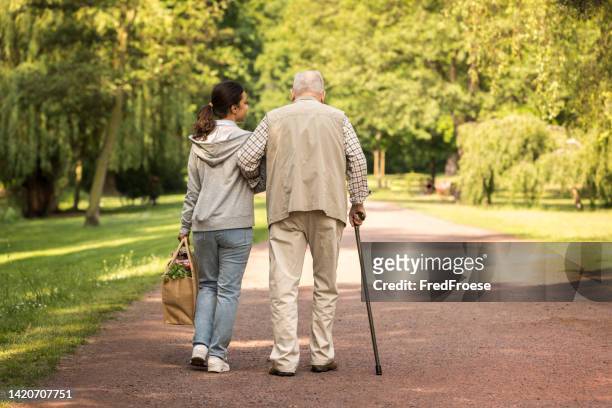 senior man with wheelchair and caregiver - park service stock pictures, royalty-free photos & images