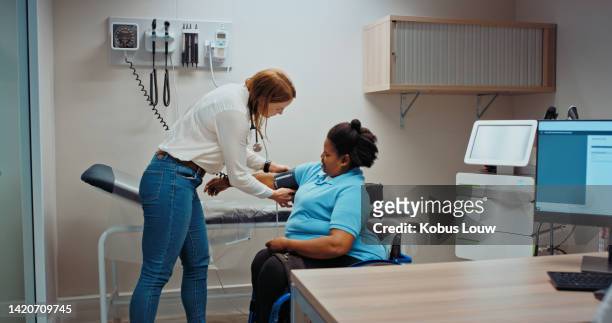 woman doctor taking patient blood pressure in hospital consultation or examination room. trust, insurance and private healthcare worker or medical professional test diabetes with clinic equipment - hospital visit stock pictures, royalty-free photos & images