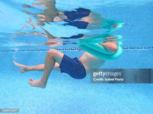 underwater shot of man making exercise at pool - aquatic therapy stock pictures, royalty-free photos & images