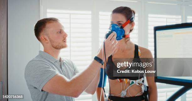 woman on sports breathing science technology lung test with innovation workout and fitness training coach at lab. girl athlete with personal trainer on future medical health sport exercise research - breath test stockfoto's en -beelden