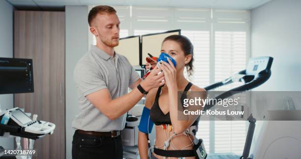 woman using sports science technology for breathing, health and blood pressure test. girl at fitness, exercise and wellness facility for scientific research or training healthcare medical assessment - breath test stockfoto's en -beelden