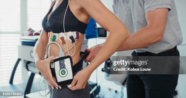 fitness test of high performance athlete with a coach in a health center using digital technology. closeup of a personal trainer testing an active, fit and athletic woman's cardio - electrode stock pictures, royalty-free photos & images