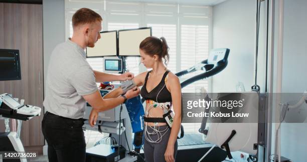 fitness, technology and woman with health tech testing blood pressure for heart rate check or monitor breathing. athletic female in prototype test for exercise, wellness and training at a clinic. - womans clinic heart stockfoto's en -beelden