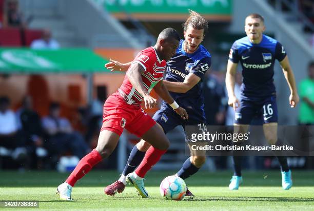Carlos Gruezo of FC Augsburg battles for possession with Ivan Sunjic of Hertha BSC during the Bundesliga match between FC Augsburg and Hertha BSC at...