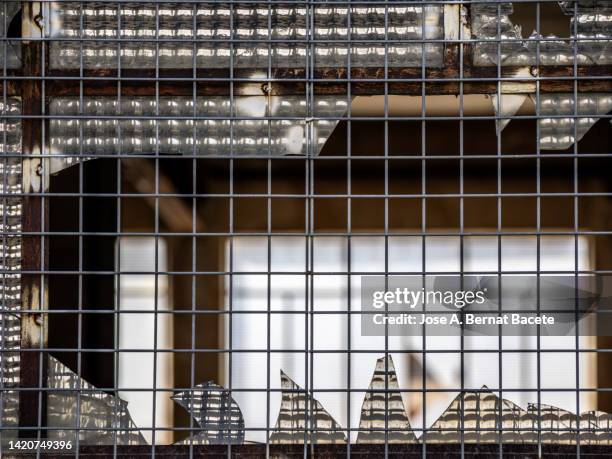 close-up of the metal window with holes and broken glass. - bullet hole in wood stock pictures, royalty-free photos & images