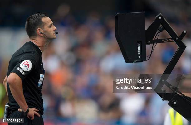 Referee Andy Madley watches the screen before disallowing West Ham United's equalising goal due to a foul on Chelsea goalkeeper Edouard Mendy by...