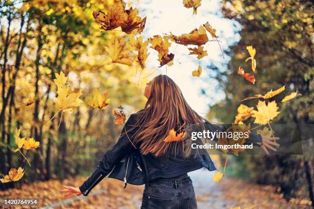 teenage girl enjoying fall leaves - drops back stock pictures, royalty-free photos & images